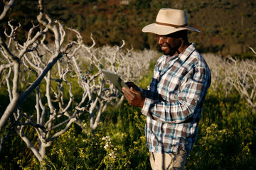 Farmer inspects a fruit crop using technology to keep keep record.