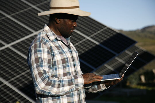 A farmer inspects his solar panels for smart farming.