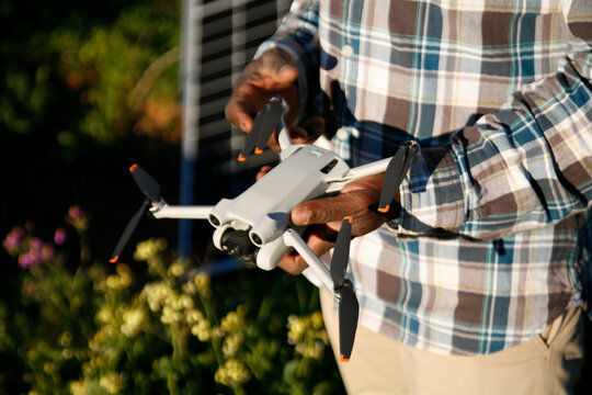 A farmer holding a drone used for smart farming.