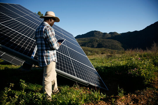 Renewable energy worker inspects a solar panel.