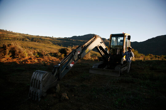 A farmer with an excavator digger for agriculture. 