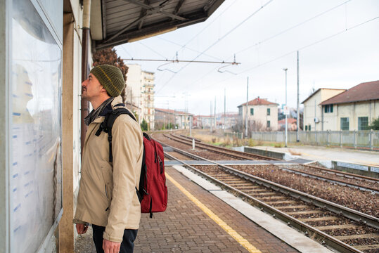 Man checking train schedule in train station