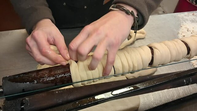 Rolling Trdelnik Dough. Close up of traditional Czech sweet pastry street food being prepared.