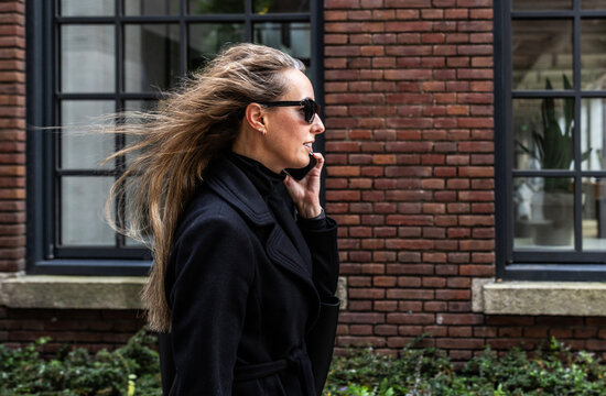 Modern Businesswoman walking on the street on the phone.