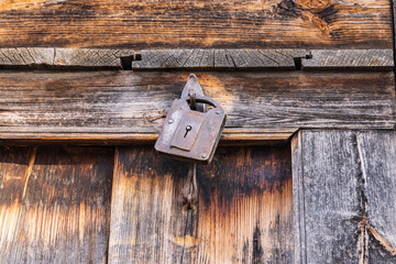Khan Sahib Tehsil, Jammu and Kashmir, India. A rusted padlock on a wooden door.