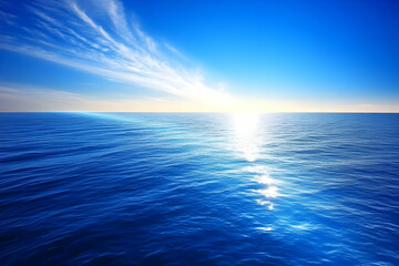 Obraz premium Sunlight Reflects on Deep Blue Ocean Water Under a Wispy Cloud Sky