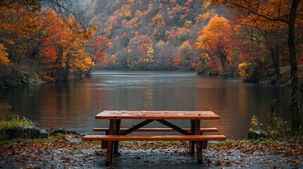 Obraz premium Autumnal Picnic Table Beside Calm River And Colorful Trees