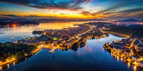 Obraz premium Experience breathtaking 4K slow-motion drone footage of a city at night, beautifully illuminated near a lake.