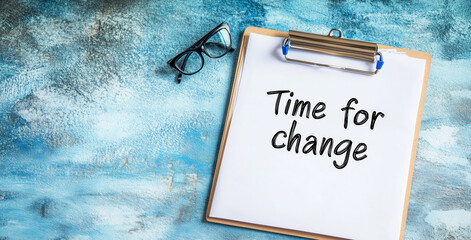 Time for Change Message on Clipboard with Reading Glasses Against Blue Background