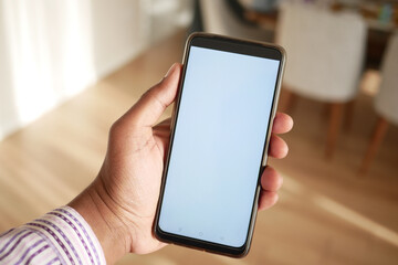 A Hand Firmly Holding a Smartphone That Has a Blank Screen Displayed