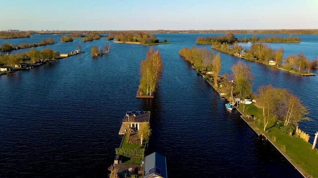 Explore the beauty of the Netherlands as tranquil waterways meander through lush islands. This serene landscape showcases natures harmony cradled by the evening glow.Vinkeveense Plassen Netherlands