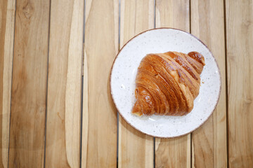 top view of fresh baked croissant on plate with copy space 