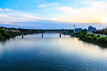 Fototapeta premium A bridge spans a river with a beautiful blue sky in the background