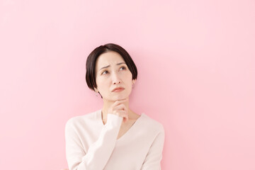 悩む・考える・困る女性・ピンクバック