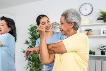 Group of elderly man and woman doing exercise with trainer at nursing home. 