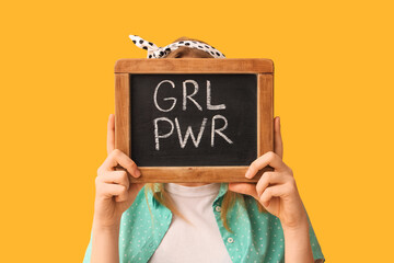 Pin-up woman holding chalkboard with text GIRL POWER on yellow background