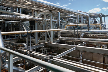 Complex network of pipelines in a chemical plant showcasing industrial processes under a clear blue sky