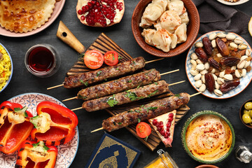 Traditional Eastern dishes and Koran on black table. Ramadan celebration