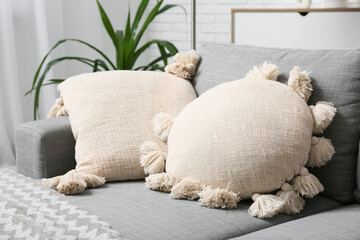 Grey sofa with soft cushions in living room