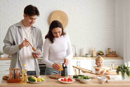 Little boy with his parents cooking Fajita in kitchen - Powered by Adobe
