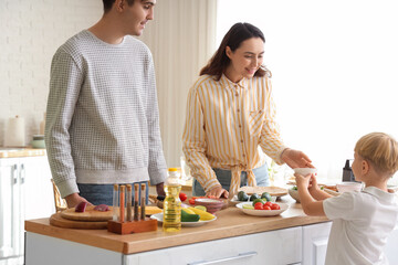 Cute little boy with his parents cooking Fajita in kitchen