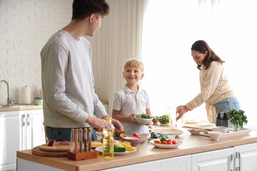 Cute little boy with his parents cooking Fajita in kitchen