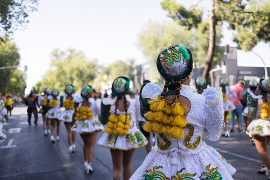 Hispanic dancers walking in formation during a street parade. Dia de la hispanidad