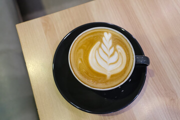 A cup of hot latte coffee on the table for breakfast
