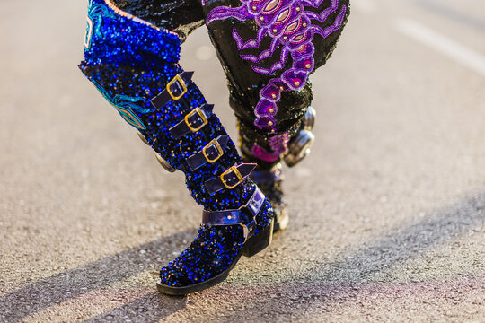 Dancer wearing glittery blue boots and embroidered pants during hispanic parade. Dia de hispanidad