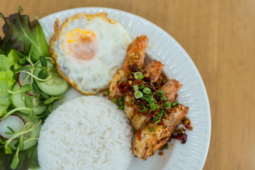 Stir fried shrimp with garlic and chili served together with steamed rice and find egg on white plate