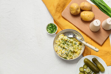 Bowl of tasty potato salad with dill, green onion and pickled cucumbers on white background