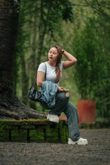 Naklejka premium Happy Woman in Casual Outfit Enjoying a Peaceful Forest Setting Outdoors