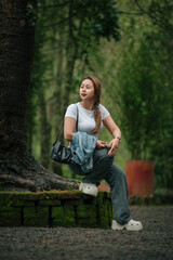 Obraz premium Happy Woman in Casual Outfit Enjoying a Peaceful Forest Setting Outdoors