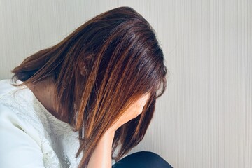 顔を覆う女性、悩みイメージ