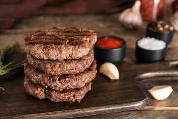 Tray with tasty meat cutlets on wooden background, closeup