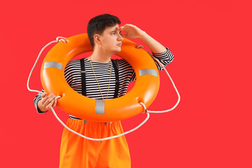 Male sailor with rescue ring on red background