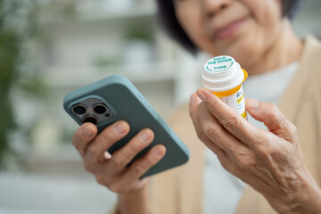 asian senior woman using smartphone searching prescription on bottle medicine,pill label about...