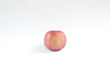 A Fuji apple, or Malus pumila, or Malus domestica on a white background. This apple has a yellowish-red skin color and a sweet honey flavor.