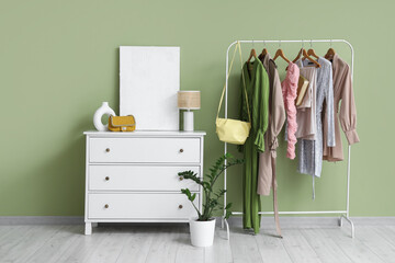 Interior of dressing room with stylish bags, commode and clothes rack