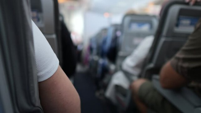 Passenger arm resting on airplane seat during flight