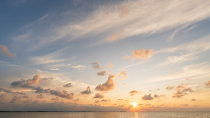 Fototapeta premium Sunset sky Clouds over sea in the Evening with Orange, Yellow sunlight on golden hour, Horizon sea sky landscape nature background