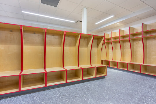 Empty team locker, changing room with traditional open wooden lockers with a red trim. - Powered by Adobe