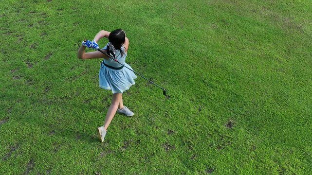 Aerial view asian girl play golf on green golf course, Woman golf player swing golf club practice, Asian girl golf player, People lifestyle.