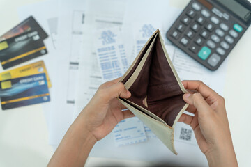 Stressed and headache woman with large bills or invoices no money to pay to expenses and credit...