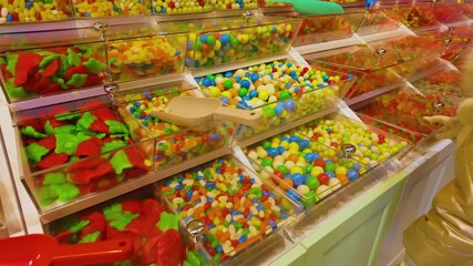 Candy shop display with colorful sweets in transparent bins, including gummy bears and jelly beans - Powered by Adobe