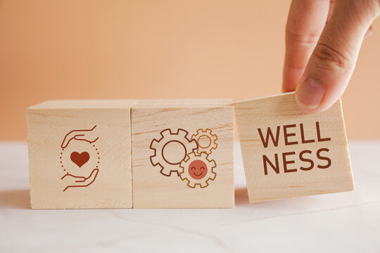 Hands holding wooden cube blocks with wellness icons, positive mental health, life balance concept