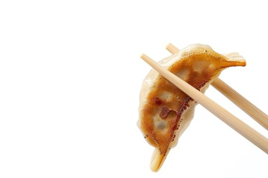 Chopsticks picking up gyoza dumpling food.