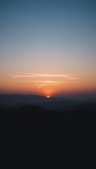 Obraz premium Sunset Over Silhouetted Mountain Range Landscape