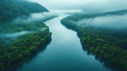 Aerial river photography capturing a serene, fog-covered river winding through a mountainous region