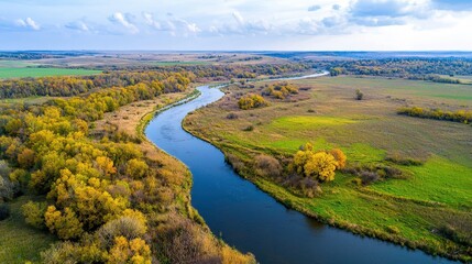 Fototapeta premium High-resolution drone image of a meandering river through autumn forest vibrant colors